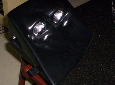 1993 Ford Probe - This black car part features two distinct round headlights, possibly from a vehicle's front end.
