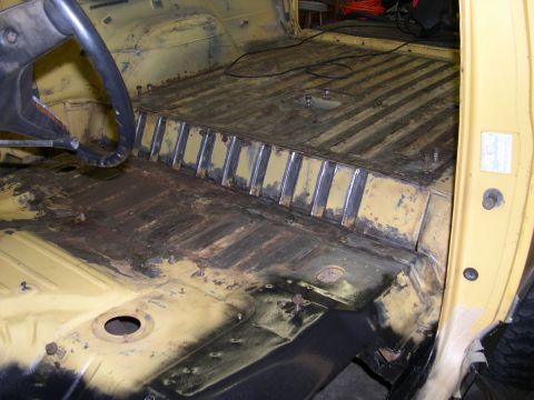 1982 Ford Bronco - The interior floor of the vehicle shows significant rust and evidence of repair work.