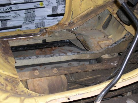 1982 Ford Bronco - The undercarriage of the vehicle shows significant rust and damage to the frame and floor pan.