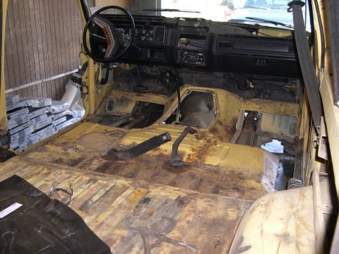1982 Ford Bronco - Interior of a 1982 Ford Bronco undergoing restoration, with floor pans removed and dashboard visible.