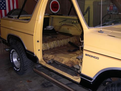 1982 Ford Bronco - This 1982 Ford Bronco shows its interior and side, with visible rust on the floor panels.