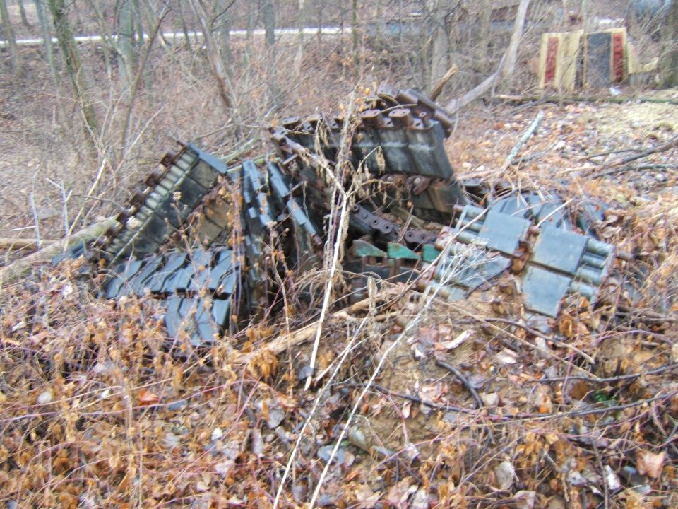 pile of old tank tracks in brush