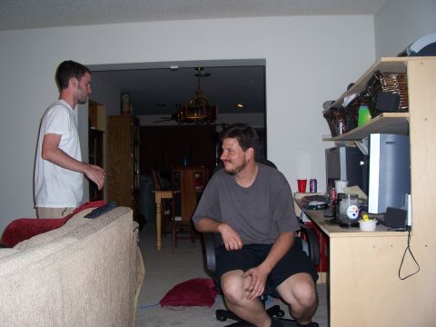 1994 Ford Probe - Two men are in a living room, one standing near a couch and the other sitting in a desk chair.