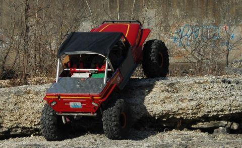 1999 Jeep TJ - Custom buggy with large tires navigates rocky terrain off-road.