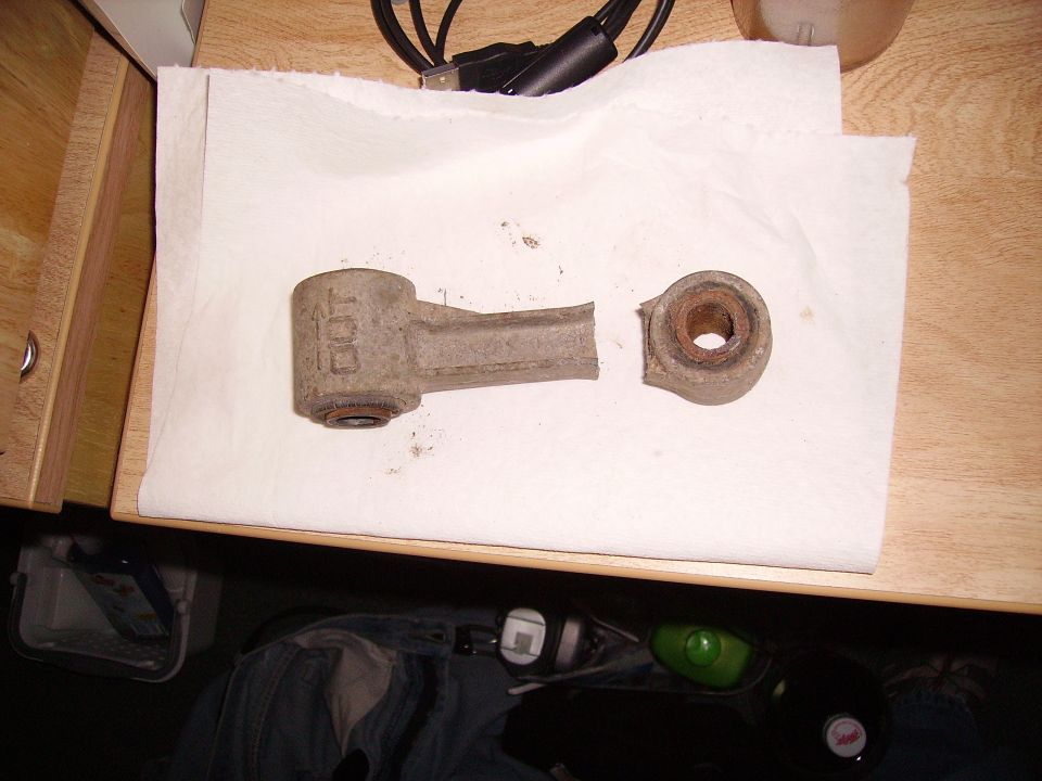 Broken suspension linkage with 'DOT' visible on one piece