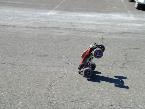 1994 Ford Bronco - RC car caught mid-air during a stunt on a paved surface.