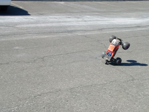 1994 Ford Bronco - A remote control car is captured mid-air on an asphalt surface.
