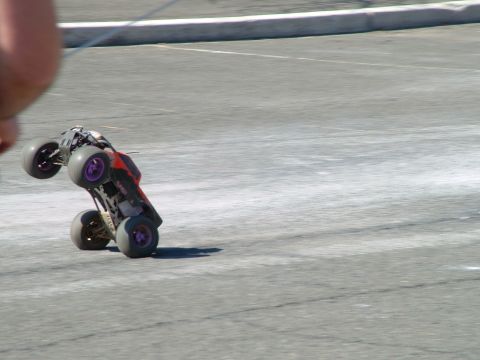 1994 Ford Bronco - A remote control monster truck performs a wheelie on a paved surface.