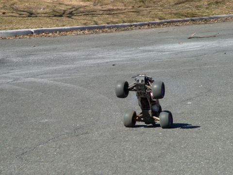 1994 Ford Bronco - A remote control monster truck is shown on its side on a paved road.