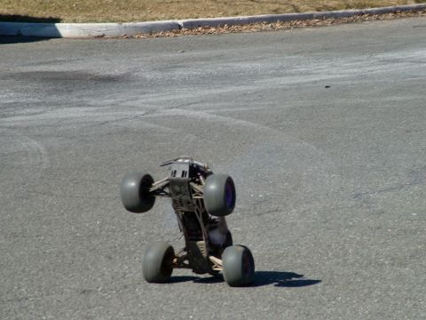 1994 Ford Bronco - A remote control monster truck is shown on its side on a paved road.