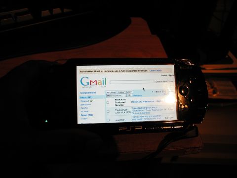 1992 Ford Taurus - A Sony PSP displays a Gmail inbox, showing email subjects and sender information.