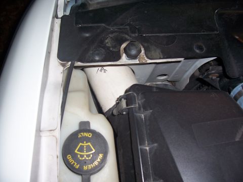 1997 Ford Crown Victoria - Close-up view of the washer fluid reservoir and other engine bay parts.