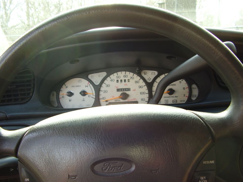 1997 Ford Taurus dashboard with odometer showing 12424. The steering wheel has a Ford logo
