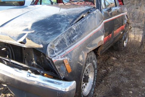 1977 Ford F-150 - This heavily damaged black pickup truck, possibly from the late 1970s, is seen from the front quarter angle.