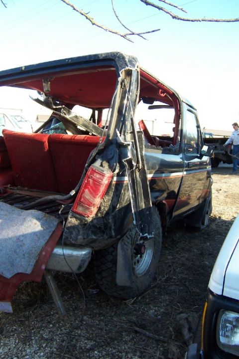 1977 Ford F-150 - This severely damaged pickup truck shows extensive rear-end collision damage, with the cab and bed significantly compromised.