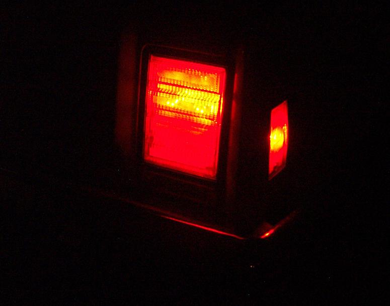 Close-up of a red taillight assembly with amber turn signal