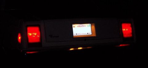 1985 Ford LTD Crown Victoria - The rear of a car is shown at night, with its license plate and taillights illuminated.