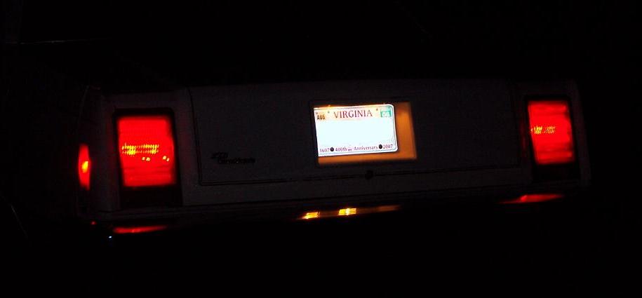 car's rear with illuminated Virginia license plate and red taillights