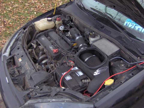 2002 Ford Focus - The engine bay of a 2002 Ford Focus features an aftermarket air intake system and other engine components.