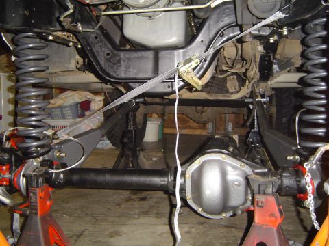 1989 Ford Bronco - The underside of a vehicle is shown with its suspension and differential components visible.