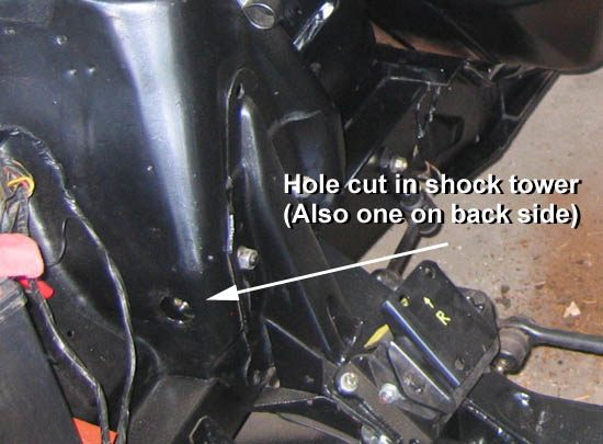 Hole torched in shock tower to access control arm zirc fitting. Installed by previous owner. I would have used a hole saw.