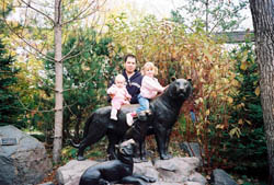 1993 Ford Taurus - Family poses with panther statues in a park during autumn.