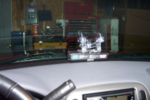 2005 Ford Explorer - Interior shot of a vehicle's dashboard a radar detector and part of the steering column.