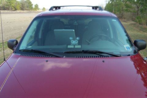 2005 Ford Explorer - Front view of a red 2005 Ford Explorer with a laptop on the dashboard and a roof rack.