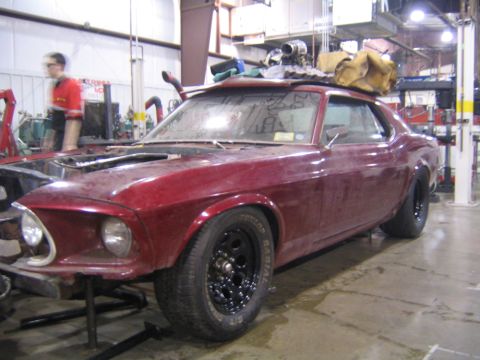 1969 Ford Mustang - This 1969 Ford Mustang is undergoing work in a garage, with its hood off and resting on stands.