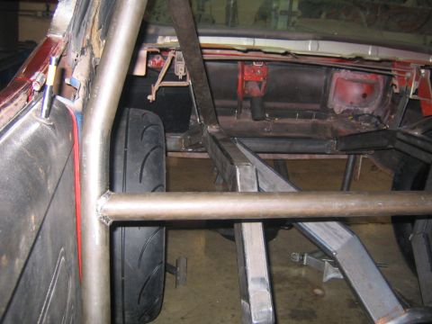 1969 Ford Mustang - Custom roll cage and frame installed in a car's interior, with a wide tire visible.