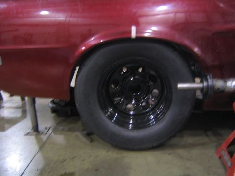 1969 Ford Mustang - Close-up view of a red vehicle's modified rear wheel well and tire.