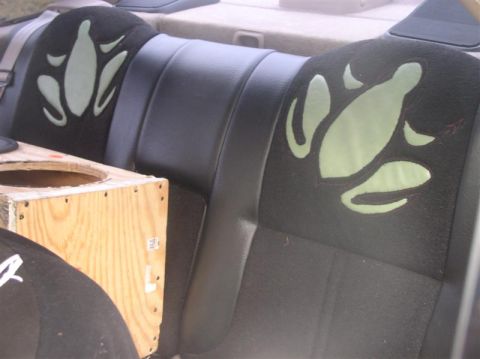 1997 Ford Taurus - The rear seats of a car feature custom graphics, with a wooden subwoofer box visible.