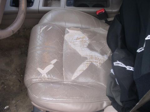 1997 Ford Taurus - Interior shot of a worn and damaged car seat with visible padding and stitching.