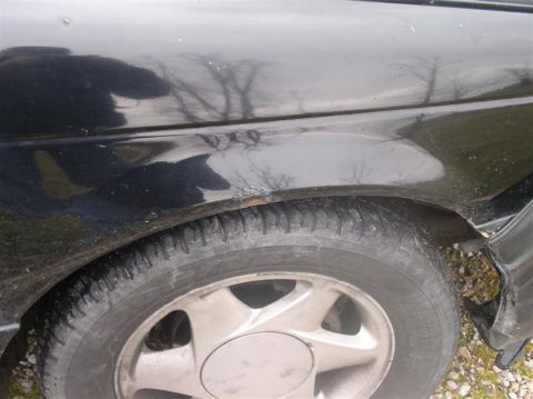 1997 Ford Taurus - Close-up of a car's fender and wheel, showing a portion of the side profile.