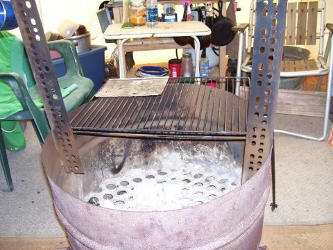 1992 Ford Bronco - This grill features perforated metal sides and a grate over an ash-filled base, suggesting it is used for cooking.