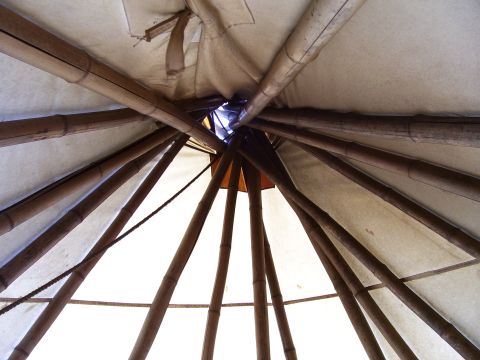 1992 Ford Bronco - The interior structure of a teepee, showing the converging wooden poles and fabric covering.