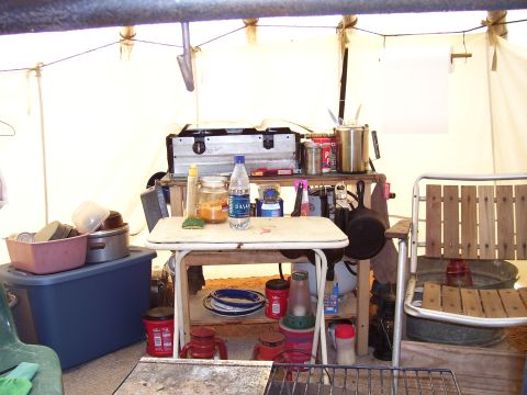 1992 Ford Bronco - A view inside a tent showing a well-organized campsite kitchen with various cooking and storage items.