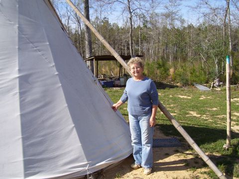 1992 Ford Bronco - A woman poses next to a large teepee structure in an outdoor setting with trees in the background.