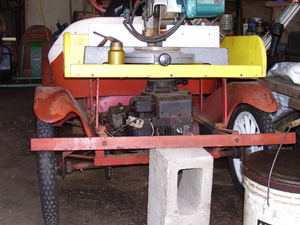 Custom motorized cart with red fenders, yellow trim, and a visible engine