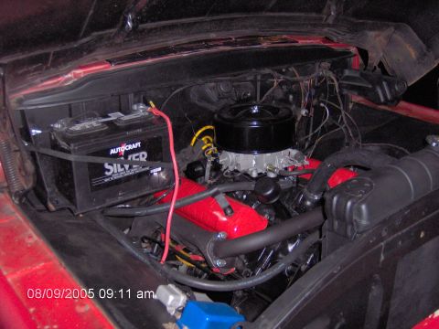 1960 Ford F-100 - Engine bay of a classic truck, likely a 1956 Ford F-100, showing the V8 engine and battery.