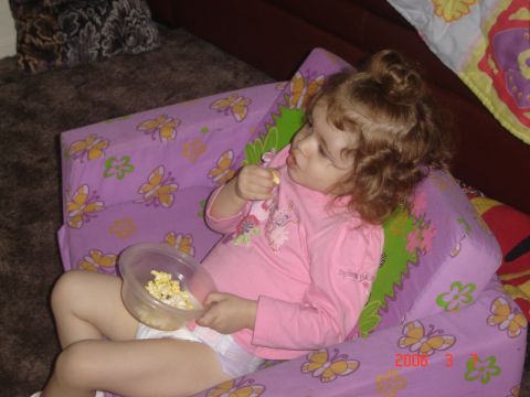 1993 Ford Bronco - A young child sits on a butterfly-patterned cushion, enjoying a snack of popcorn.