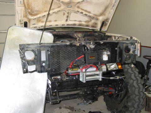 1981 Ford Bronco - The front end of a 1981 Ford Bronco is shown with the hood open, revealing a winch and other engine components.