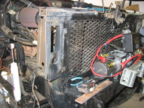 1981 Ford Bronco - Close-up of a vehicle's engine bay, showing the radiator, air intake, and a winch installation.