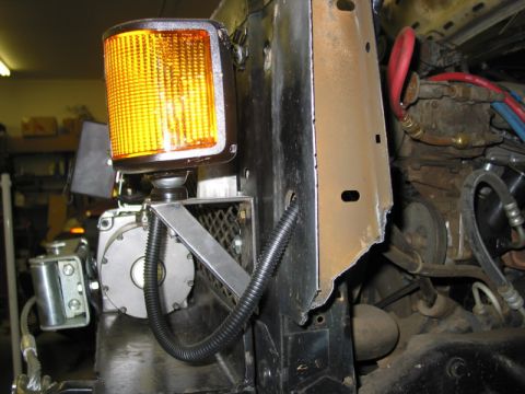 1981 Ford Bronco - This photo shows a close-up view of a vehicle's front end, focusing on a modified section with an amber light and visible engine parts.