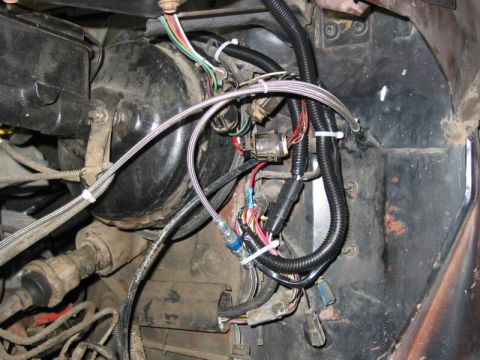 1981 Ford Bronco - Close-up view of the engine bay wiring harness and brake booster assembly.