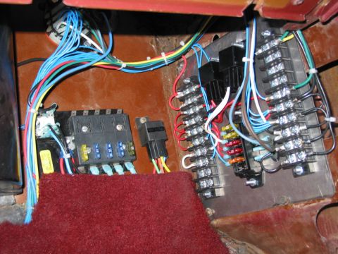 1981 Ford Bronco - A complex custom wiring harness with several fuse blocks and relays is visible, along with a section of red carpet.