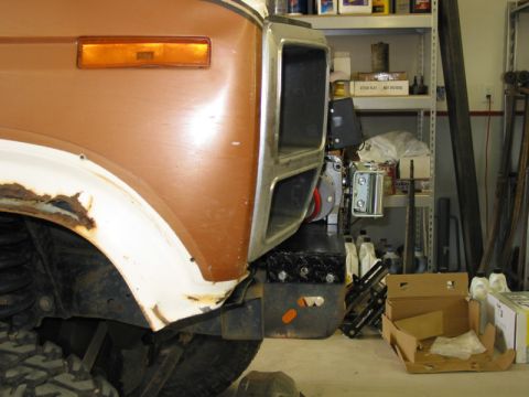 1981 Ford Bronco - Close-up of the front fender and bumper area of a 1981 Ford Bronco, showing rust and modifications.