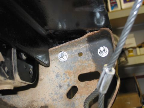 1981 Ford Bronco - Close-up view of winch mount hardware on a rusty frame, with a cable visible.