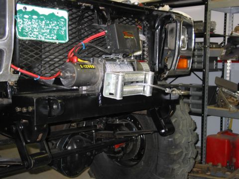 1981 Ford Bronco - A winch is mounted to the front bumper of a vehicle, with a license plate visible above the grille.