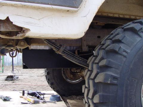 1981 Ford Bronco - Close-up of a vehicle's undercarriage, focusing on the gas tank skid plate and suspension components.